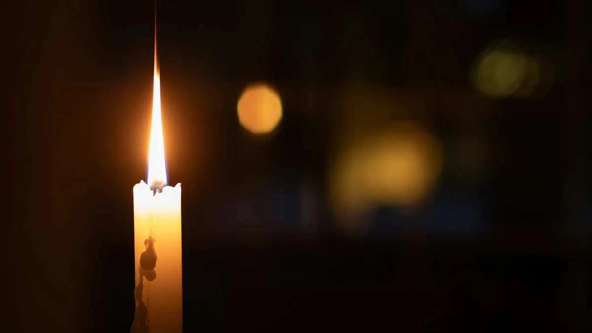 A single lit candle glowing warmly in a dark, quiet room - a Quiet Core Reset guide to 10-Minute Sleep Recovery Routine for Wired Evenings.