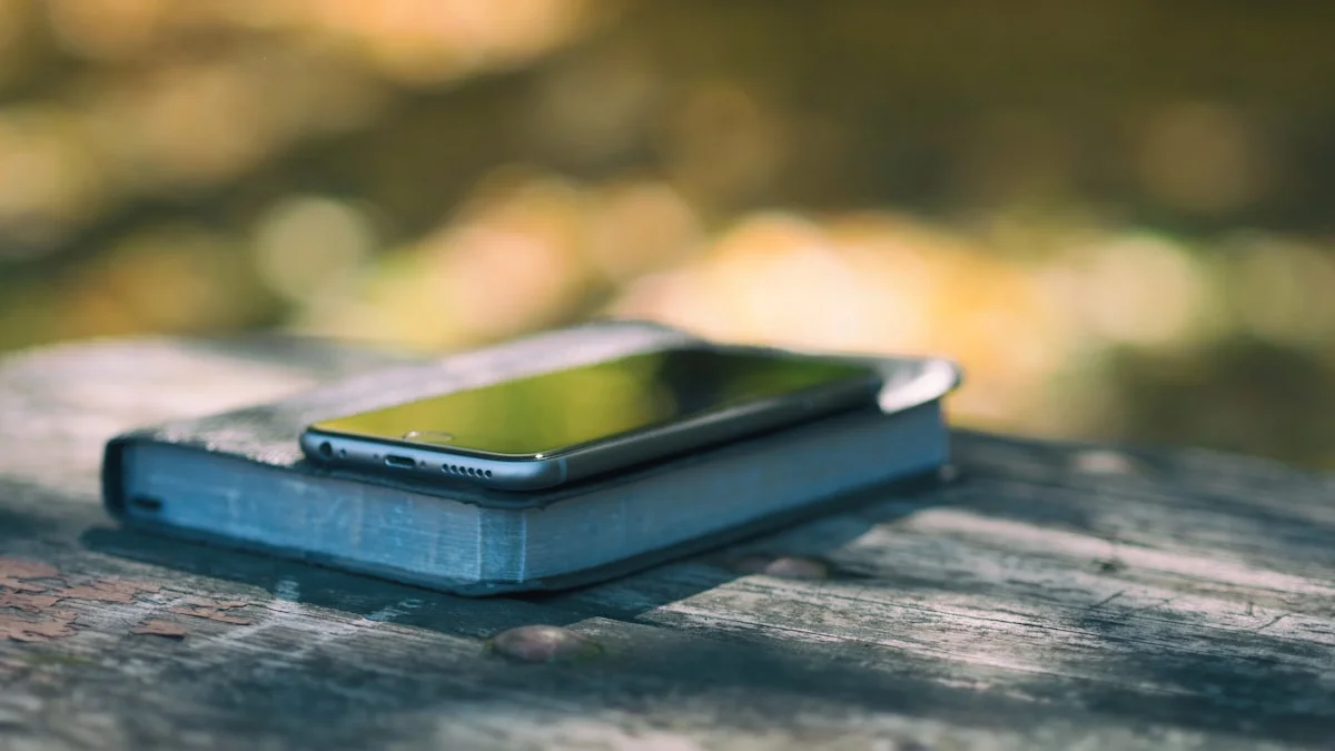 A smartphone lying face down on a hardcover book at a weathered park table, warm dappled light - a Quiet Core Reset guide to The 5-Second Pause Before You Open Your Phone.
