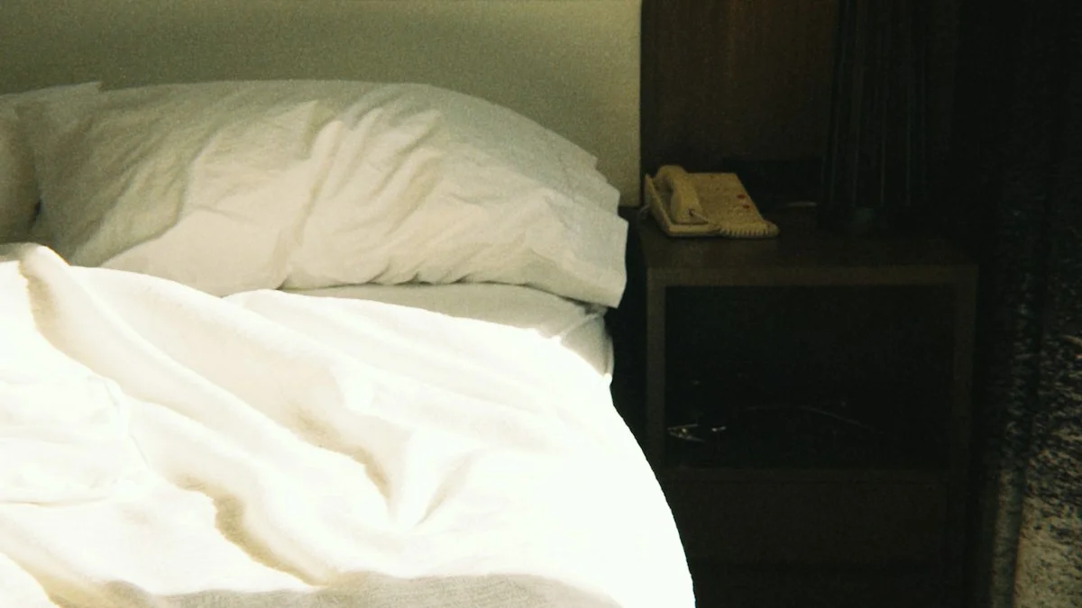 A rumpled unmade bed catching soft morning sunlight beside a warm bedside lamp - a Quiet Core Reset guide to Why 5 AM Routines and 4-Hour-Sleep Brags Are a Red Flag.