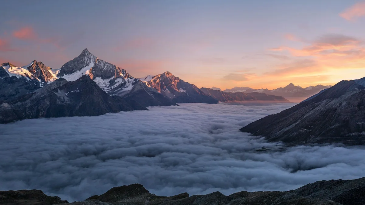 Snowy mountain peaks glowing at sunrise above a rolling sea of clouds - a Quiet Core Reset guide to 90-Second Recharge.