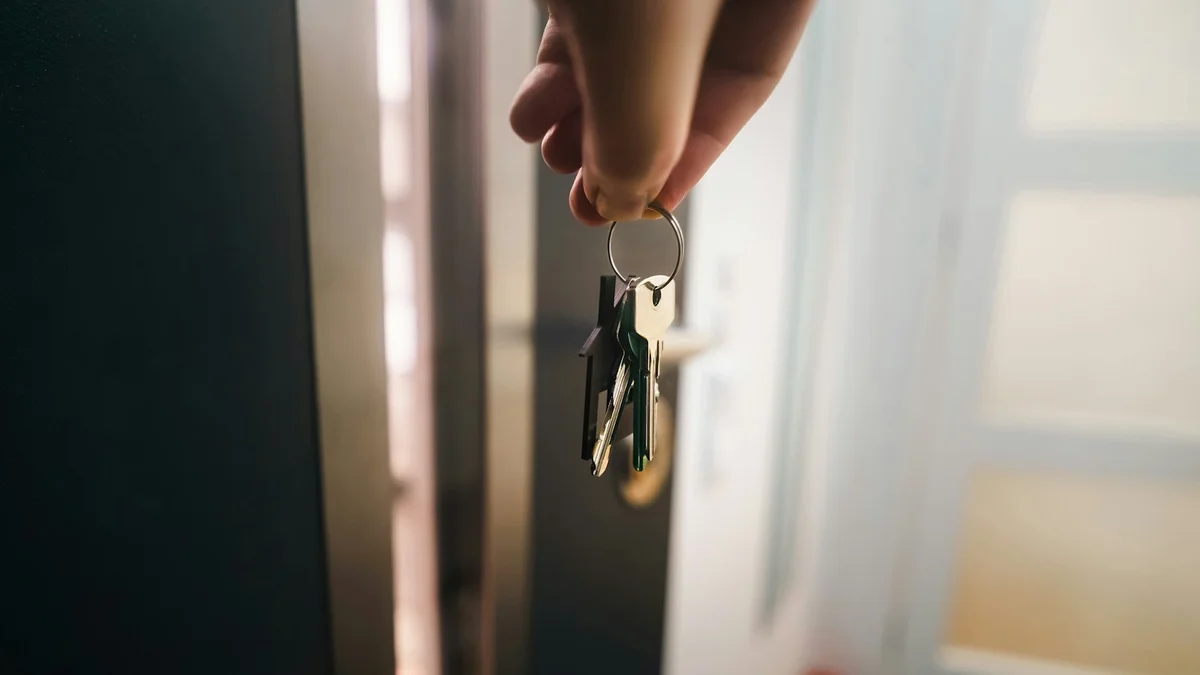 A hand holding keys in front of a warmly lit home door - a Quiet Core Reset guide to 90-Second Transition.