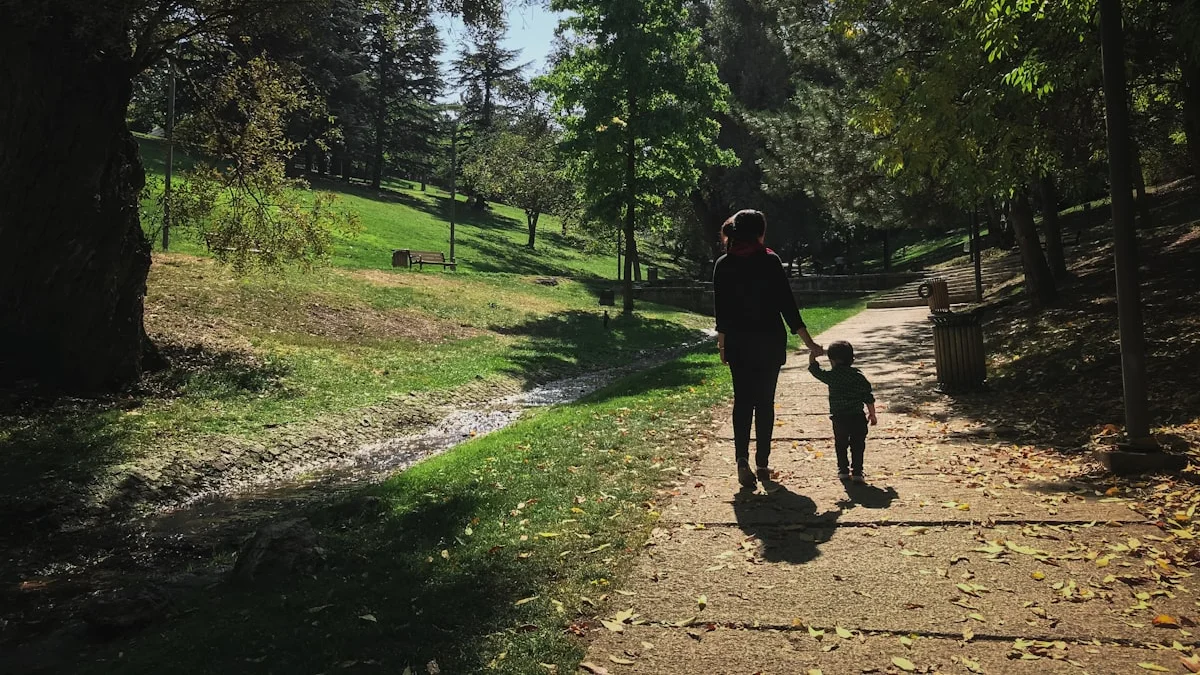 A parent and toddler walking hand in hand down a sunlit park path - a Quiet Core Reset guide to Boundaries for Parents & Caregivers.