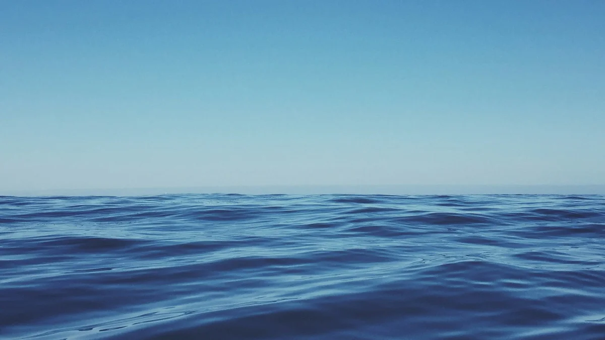 A wide expanse of calm blue ocean meeting a clear blue sky at the horizon - a Quiet Core Reset guide to Burnout Recovery After Quitting.