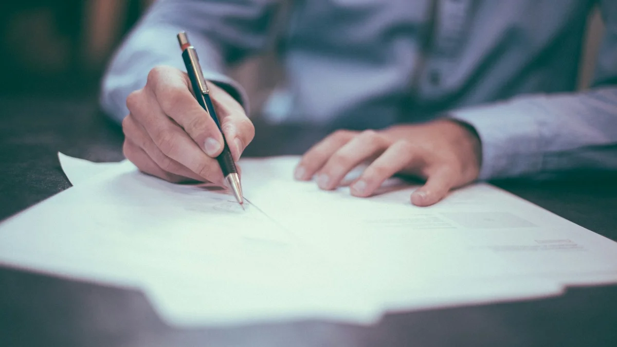 A hand writing with a pen on a sheet of paper on a desk - a Quiet Core Reset guide to Are You Recovering or Just Coping? A 3-Minute Honest Self-Check.