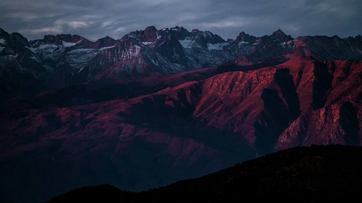 Dark red-lit mountain ridges under a moody sky at dusk - a Quiet Core Reset guide to When Burnout Recovery Itself Feels Too Hard.