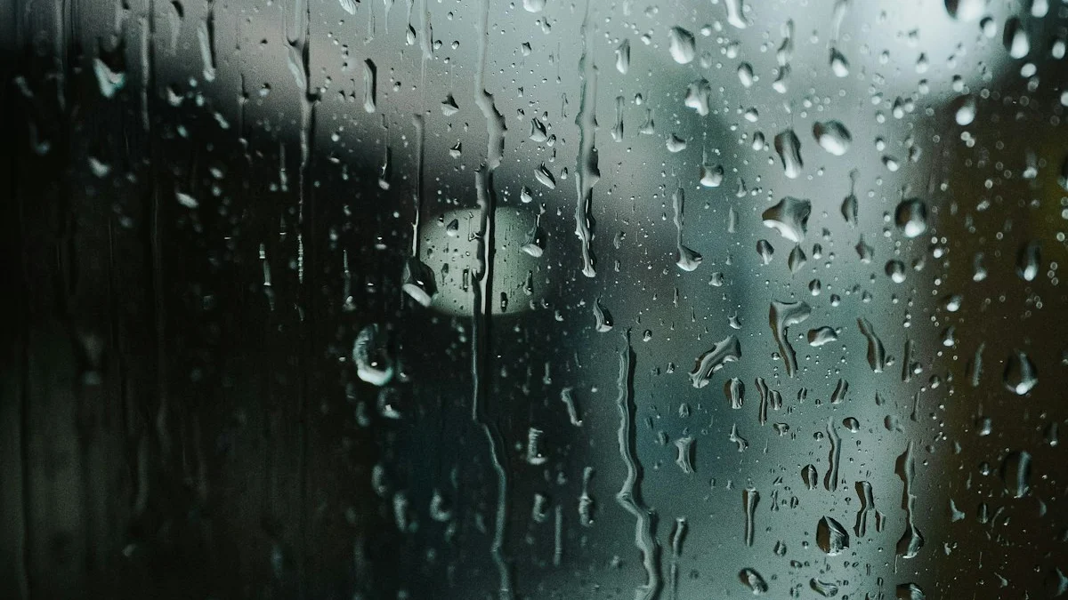 Raindrops streaking down a dark window pane under a heavy grey sky, the view blurred beyond the glass - a Quiet Core Reset guide to Catastrophic Thinking.