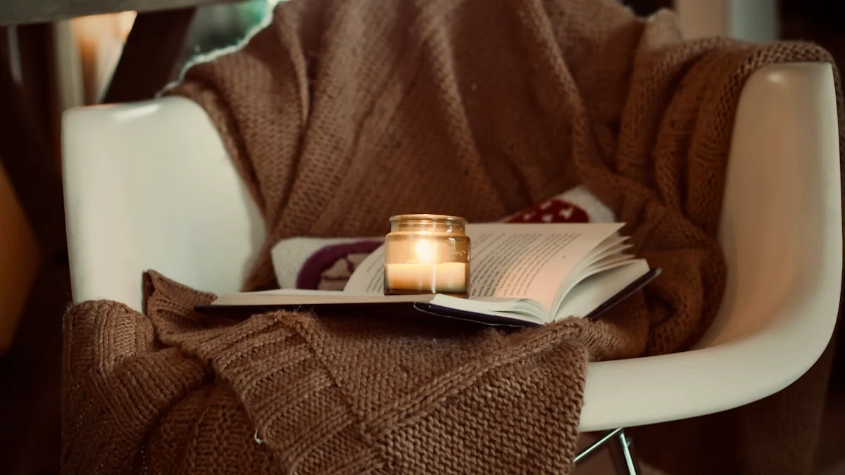 A white armchair draped with a chunky knit blanket, an open book and a lit candle resting on the seat - a Quiet Core Reset guide to How to Create Safe Space for Your Feelings.