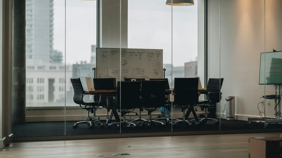 A quiet meeting room seen through glass with a view of the city - a Quiet Core Reset guide to Deep Work vs. Meetings.