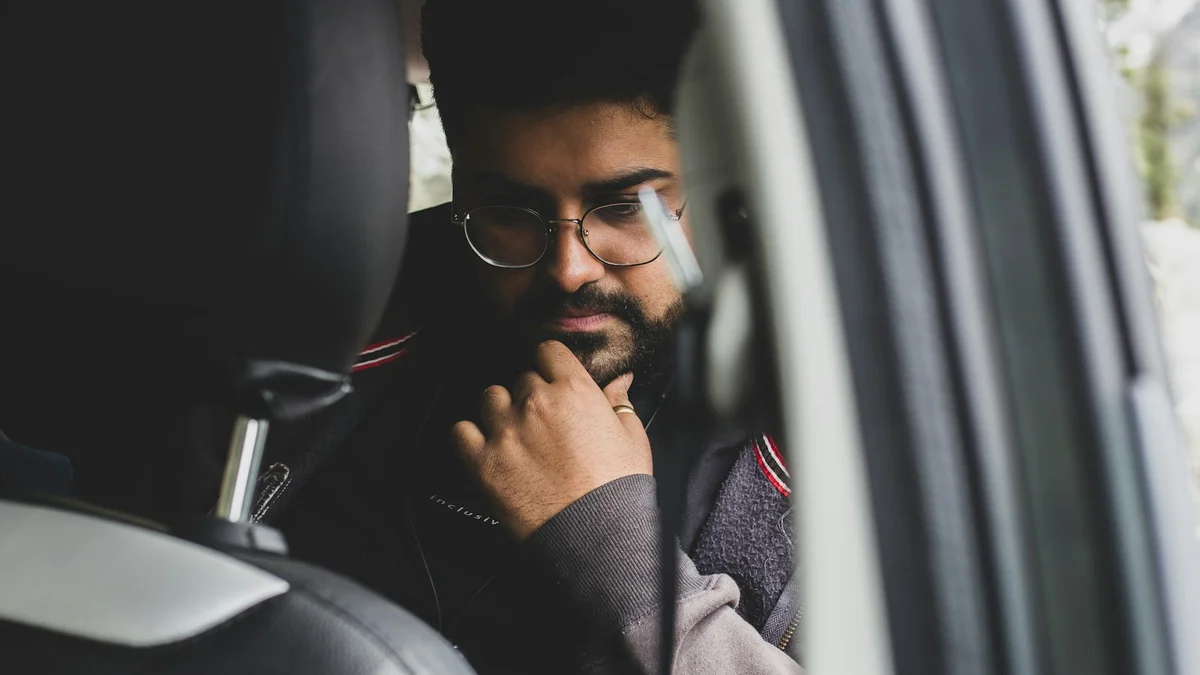 A man sitting in his car looking down after work - a Quiet Core Reset guide to Why You're Depleted After Work Every Day (It's Not Weakness).