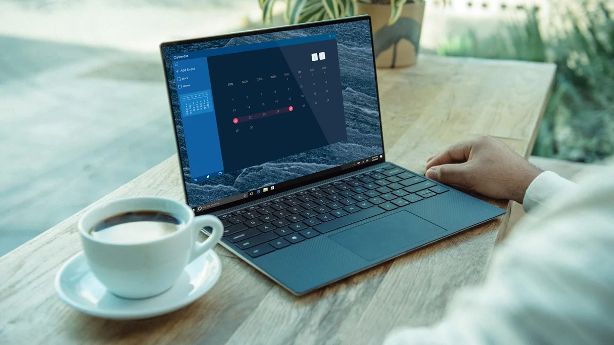 A laptop showing a calendar app on a desk with a coffee cup, a hand on the trackpad - a Quiet Core Reset guide to Digital Boundaries for Remote Workers.