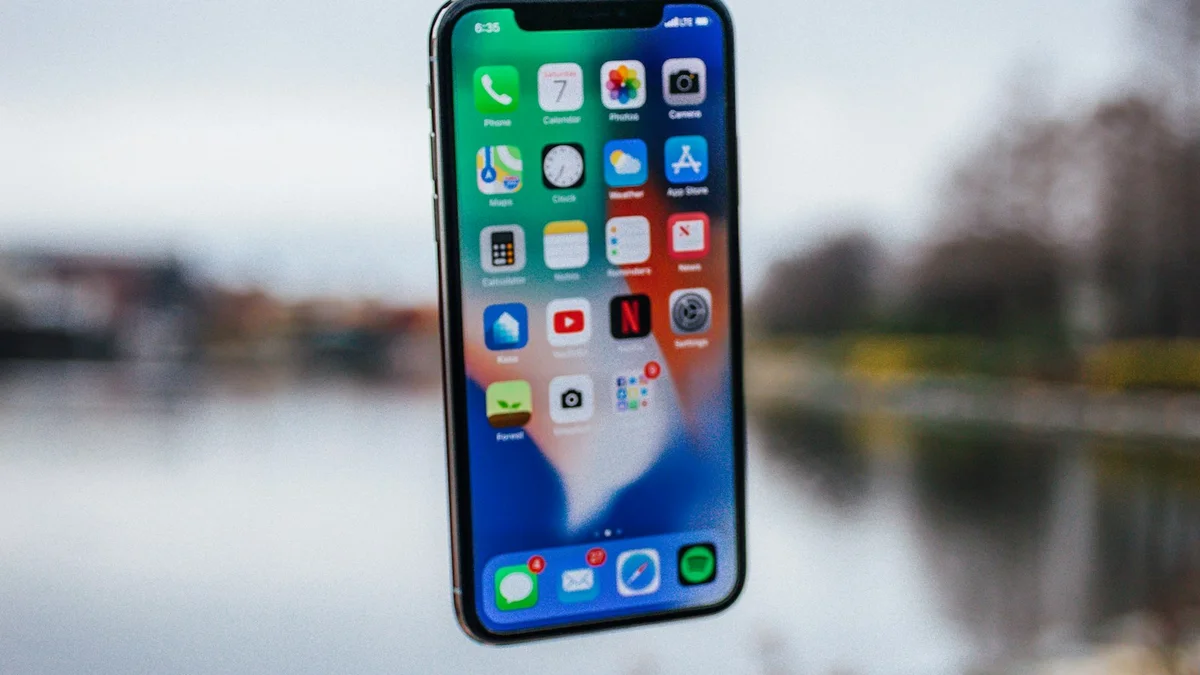 A smartphone held up against a blurred outdoor background, showing a home screen of apps - a Quiet Core Reset guide to Digital Overload Explained Simply.