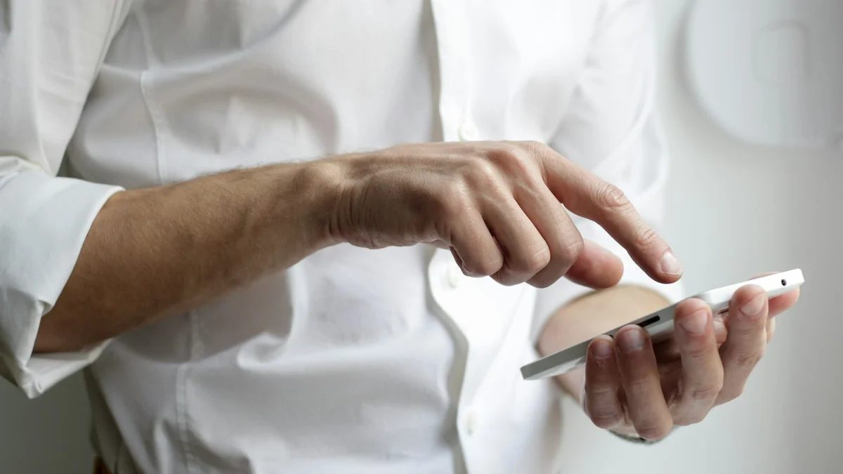 A person in a white shirt pointing at a tablet they are holding - a Quiet Core Reset guide to Is Your Phone the Problem? A 3-Minute Digital Self-Check.