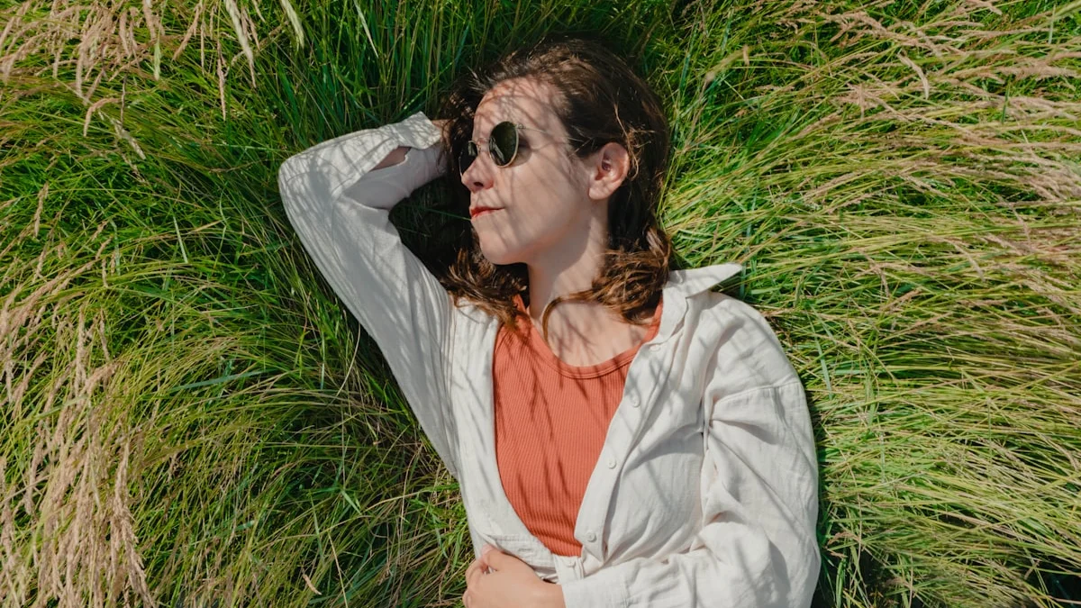 A woman lying back in tall sun-dappled grass doing nothing, warm afternoon light through the blades - a Quiet Core Reset guide to The Quiet Power of Doing Nothing.