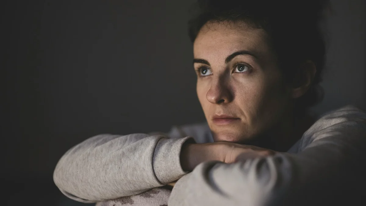 A woman resting her chin on her arms in soft evening light - a Quiet Core Reset guide to 7 Subtle Signs You're Carrying Too Much Emotional Load at Home.