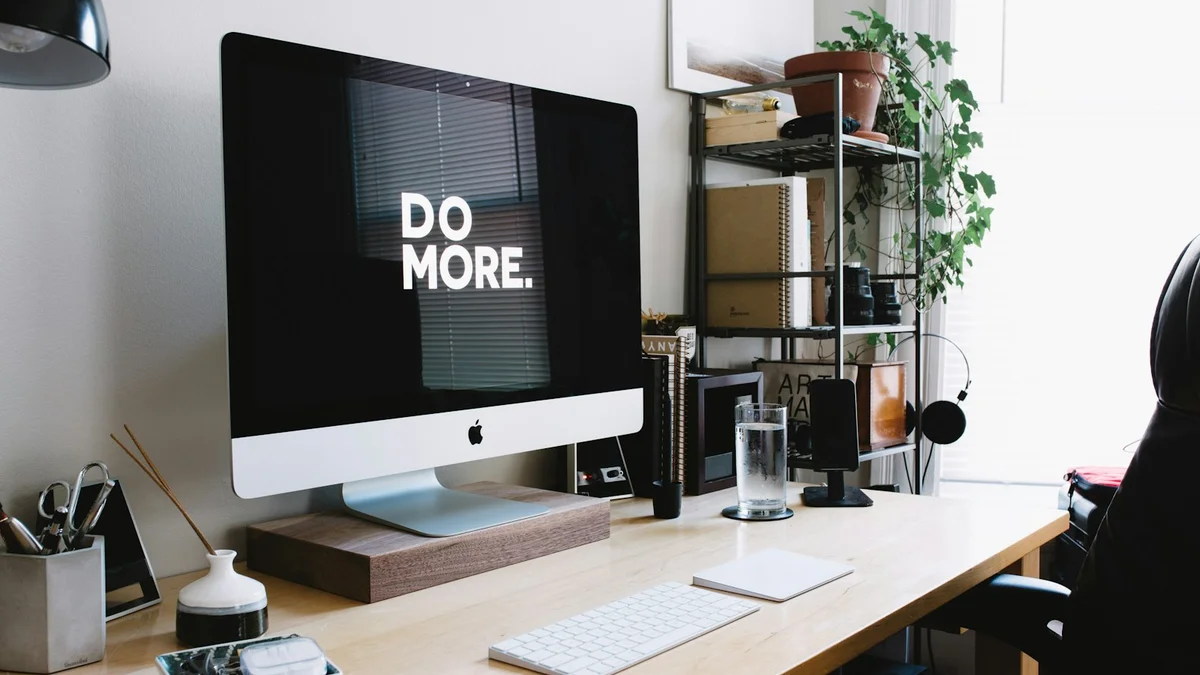 A computer monitor on a desk showing the words DO MORE, a tidy modern workspace - a Quiet Core Reset guide to Energy Batching.