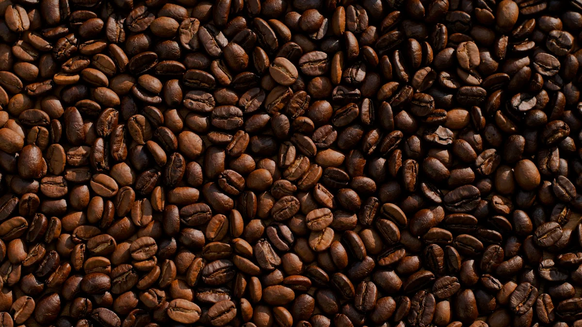 A dense close-up of roasted coffee beans, warm brown texture - a Quiet Core Reset guide to Energy Myths, Debunked.