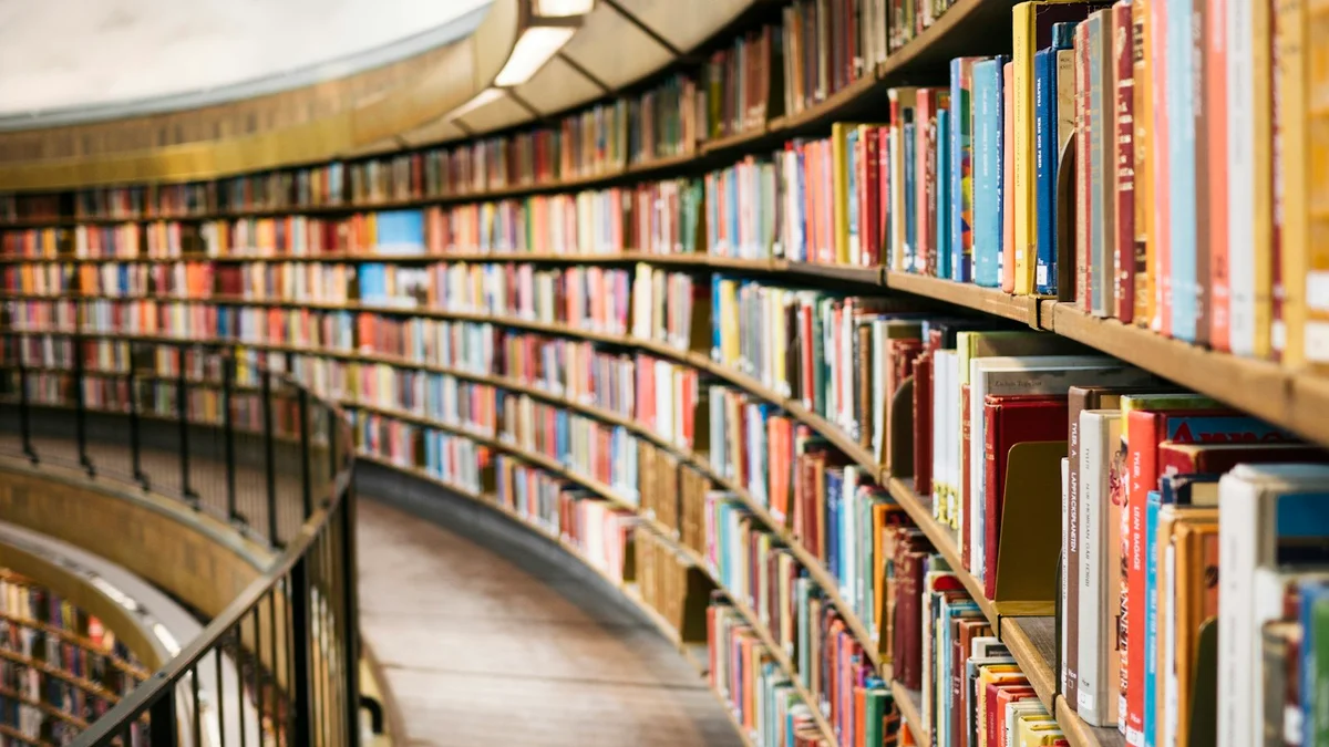 Curved bookshelves filled with colorful books, a grand library - a Quiet Core Reset guide to How I Stopped Managing Time and Started Managing Energy.