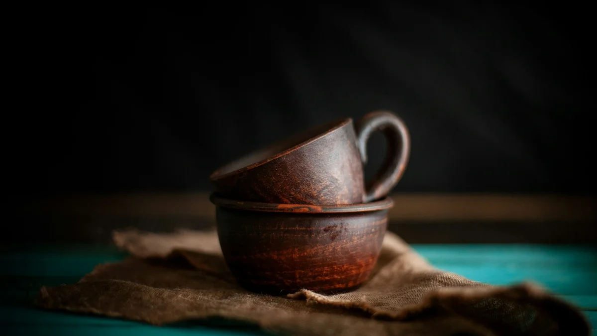 Two handmade clay cups stacked on a worn cloth - a Quiet Core Reset guide to How to Rebuild Family Energy in 10 Minutes a Day.