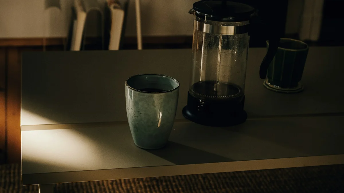 A french press and a mug resting on a table in soft morning light - a Quiet Core Reset guide to 5 Myths About Family Energy (and the Gentler Truth).