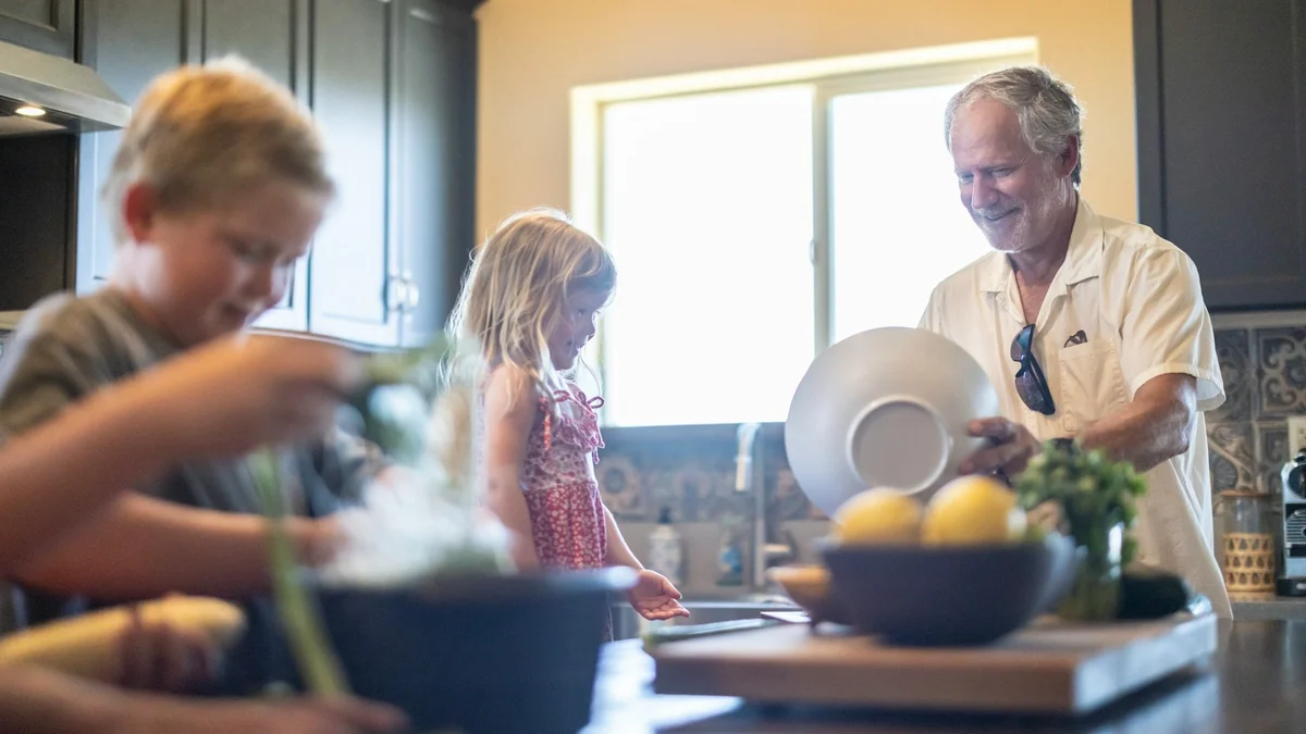 A grandfather cooking with his grandchildren in the kitchen - a Quiet Core Reset guide to Family Energy for the Sandwich Generation.