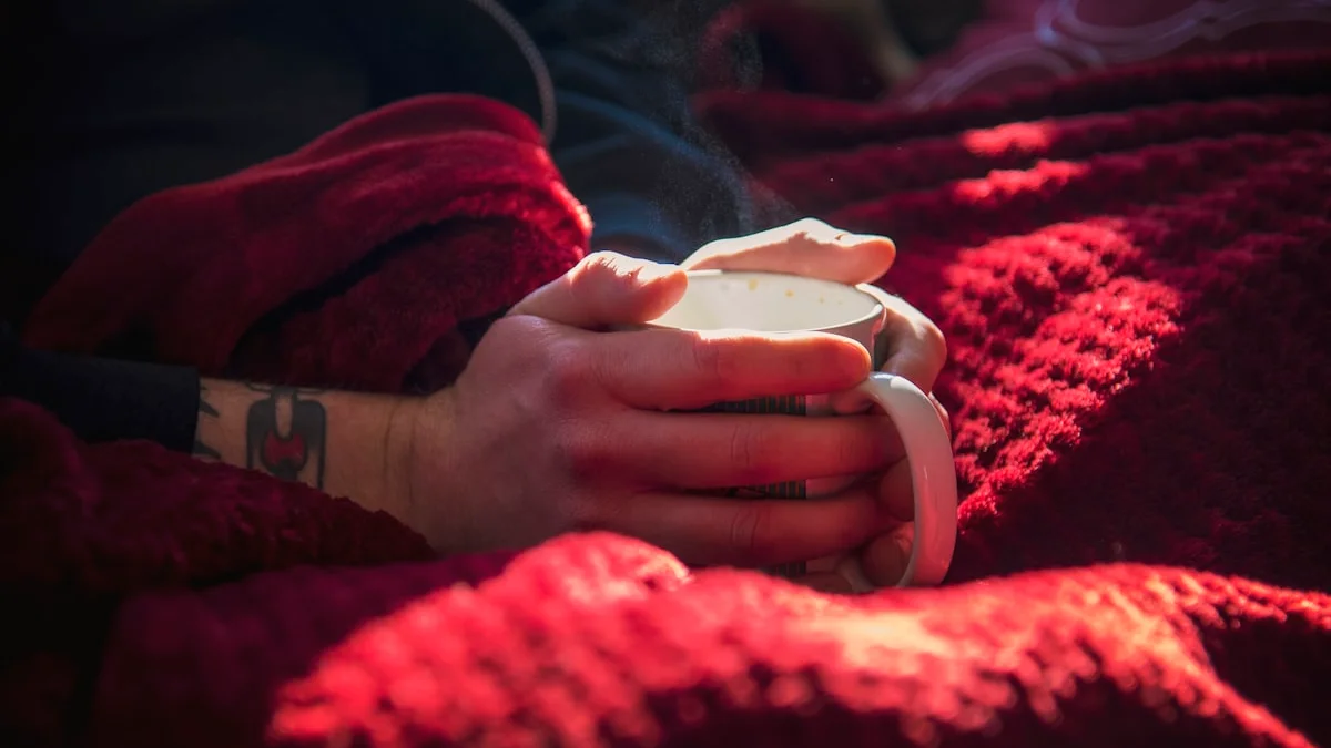 Hands cradling a steaming mug under a sun-warmed blanket, pure rest-and-digest ease - a Quiet Core Reset guide to Fight, Flight, Freeze, and the Forgotten Rest & Digest.