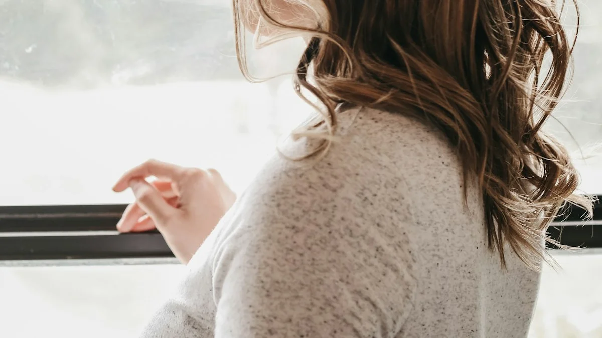 A woman with her face turned away, gazing out of a bright window - a Quiet Core Reset guide to Why You Can Be Fine on the Outside and Empty Inside.