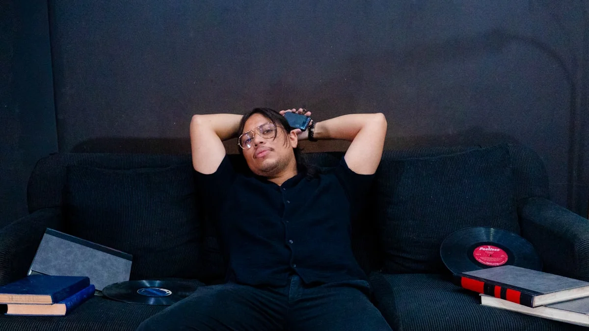 A person lying flat on a dark couch with an arm across their face, books and records nearby - a Quiet Core Reset guide to High-Functioning Exhaustion Explained Simply.
