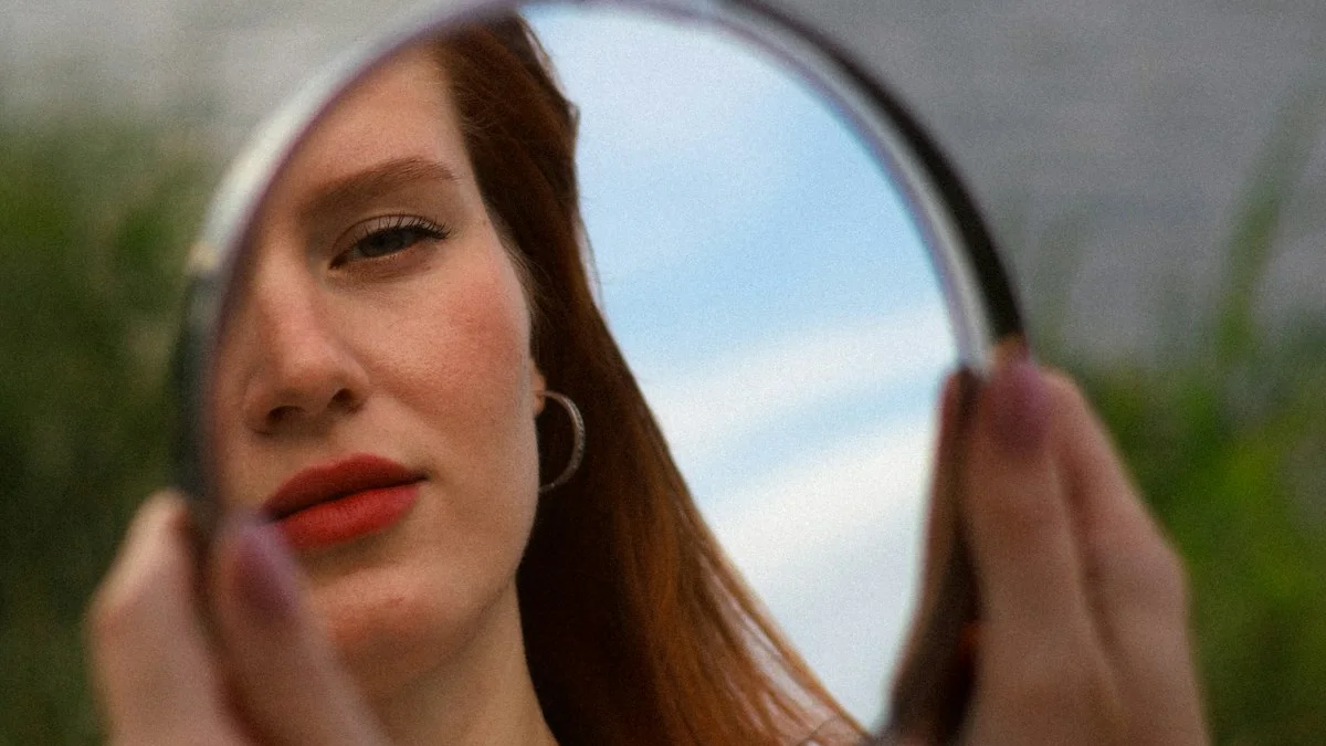 A woman holding a small round mirror that catches her face against the sky - a Quiet Core Reset guide to High-Functioning Mask.