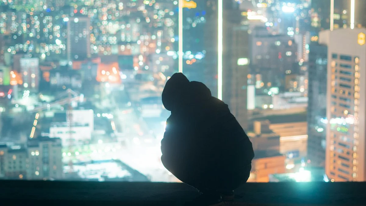 A lone figure silhouetted on a rooftop ledge overlooking a glittering city at night - a Quiet Core Reset guide to High Performers: The Comparison Race You Never Chose.