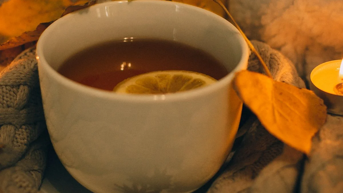 A warm cup of tea with lemon beside a lit candle and a soft knit blanket on an evening table - a Quiet Core Reset guide to How I Started Saying No.