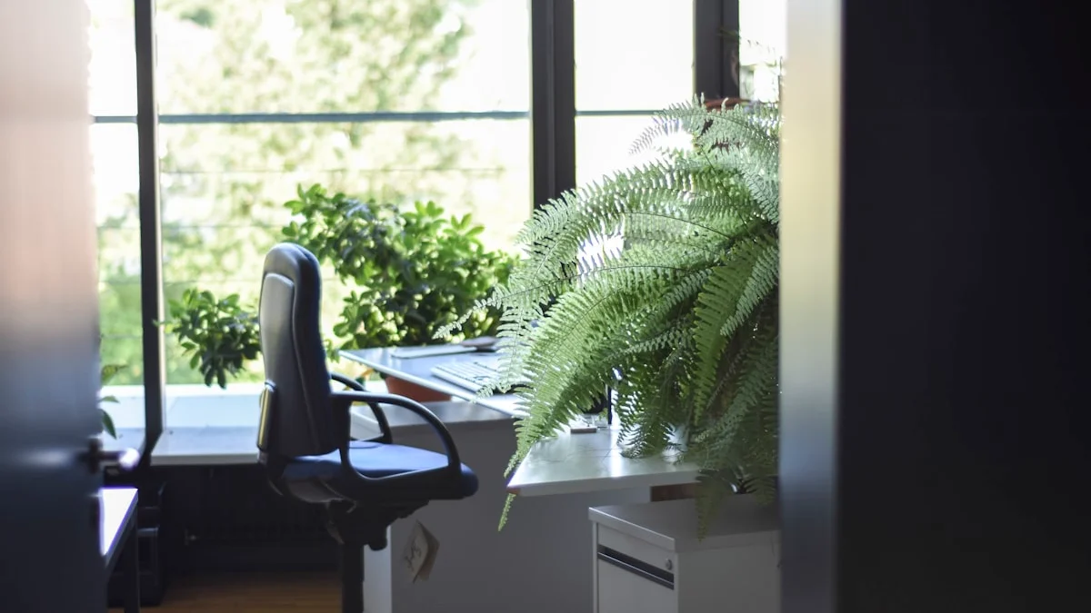 An unoccupied office desk and chair beside a large fern, lit by soft daylight through tall windows - a Quiet Core Reset guide to Hustle Culture at Work.