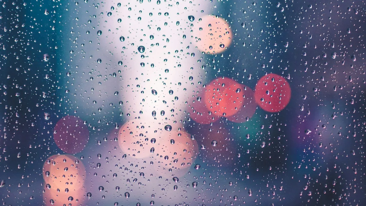 Raindrops on a window at night with soft blurred city lights beyond the glass - a Quiet Core Reset guide to I'll Sleep When Things Calm Down.