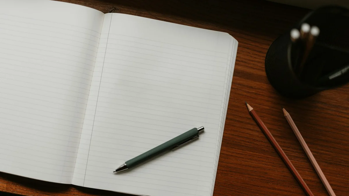 An open notebook with blank lined pages and a pen on warm wood - a Quiet Core Reset guide to Perfectionist's Inner Critic.