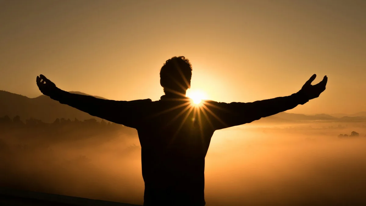 A silhouette of a person with arms spread wide toward a bright sunrise over a foggy valley - a Quiet Core Reset guide to How I Stopped Waiting for the Perfect Break and Started Taking 90 Seconds.