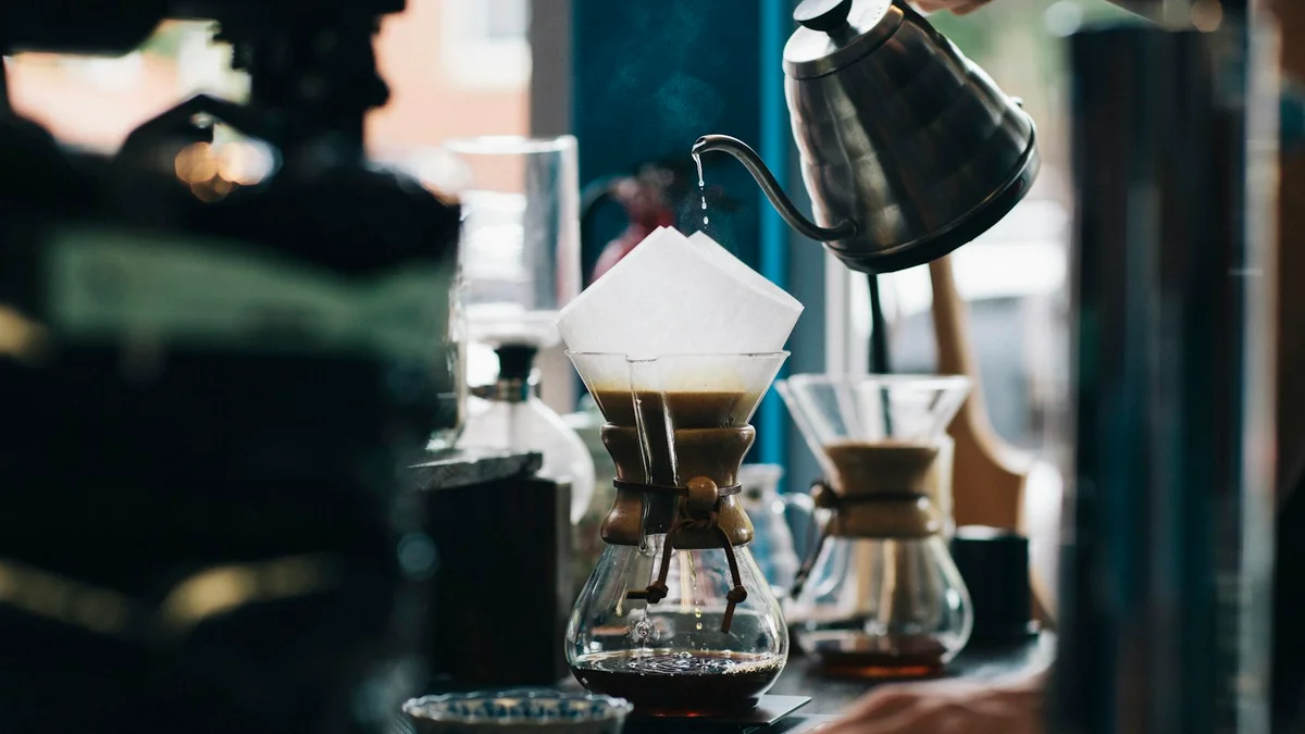 A pour-over coffee being brewed with a gooseneck kettle in a cafe - a Quiet Core Reset guide to Mindful Morning Coffee.
