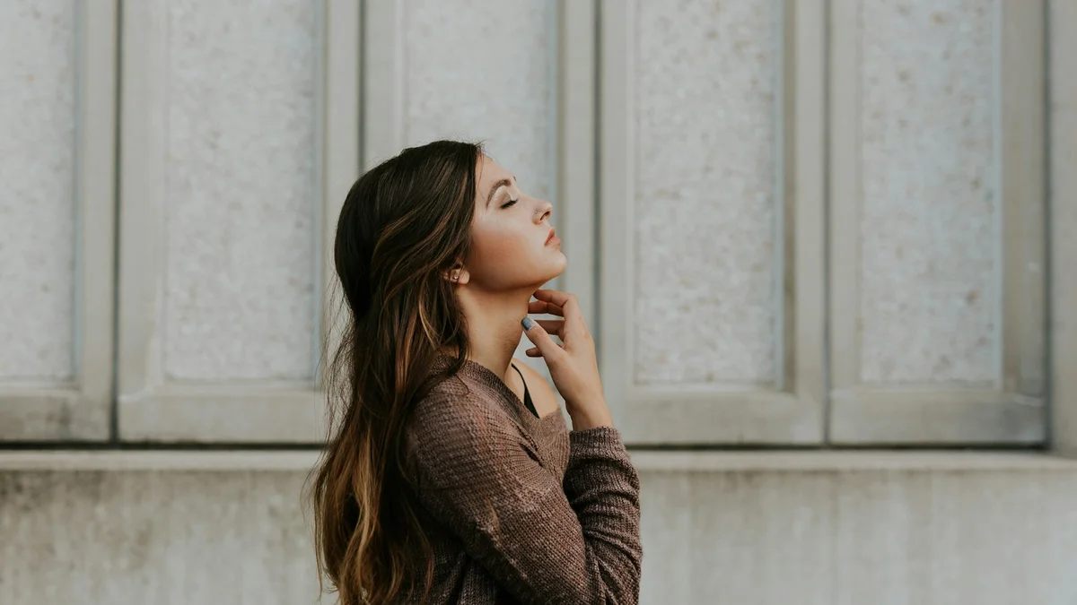 A serene portrait of a woman with dark hair, looking away, soft light - a Quiet Core Reset guide to Why People-Pleasers Are the Most Exhausted People You Know.
