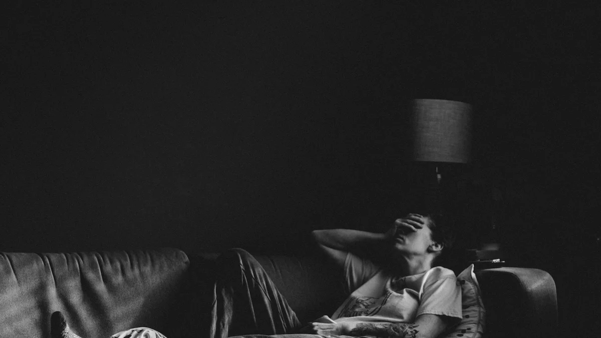 A person lying on the couch exhausted with a hand over their face - a Quiet Core Reset guide to Why Pushing Through for My Family Backfires (and What Helps).