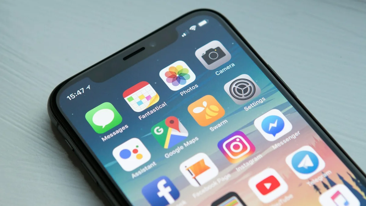 A hand holding a smartphone, its screen showing a grid of app icons - a Quiet Core Reset guide to Why Scrolling Doesn't Actually Rest You.