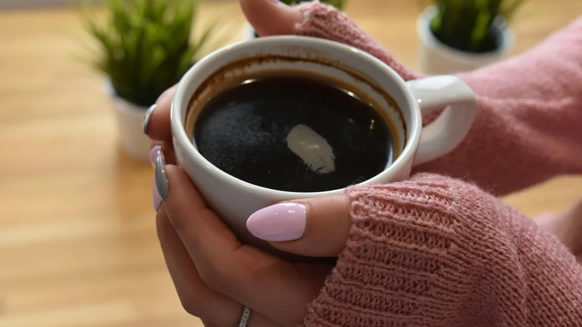 Hands in soft knit sleeves cradling a warm cup of coffee - a Quiet Core Reset guide to How to Practice Self-Compassion in 10 Minutes a Day.