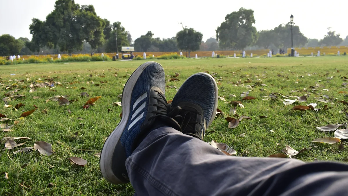 Sneakers up on the grass in a quiet hazy park, taking a break - a Quiet Core Reset guide to Does Self-Criticism Motivate You? Why the Harsh Voice Backfires.