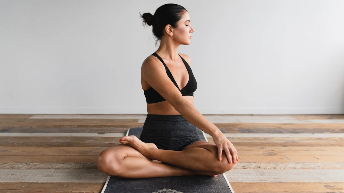 A woman seated cross-legged on a yoga mat with her eyes closed, one hand resting on her knee - a Quiet Core Reset guide to Simple Practice That Changes Everything.