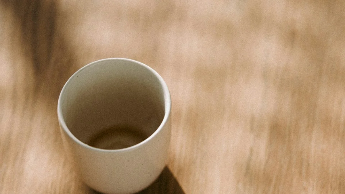 A single ceramic cup on a sunlit wooden table casting one long shadow - a Quiet Core Reset guide to The Beautiful Simplicity of Single-Tasking.