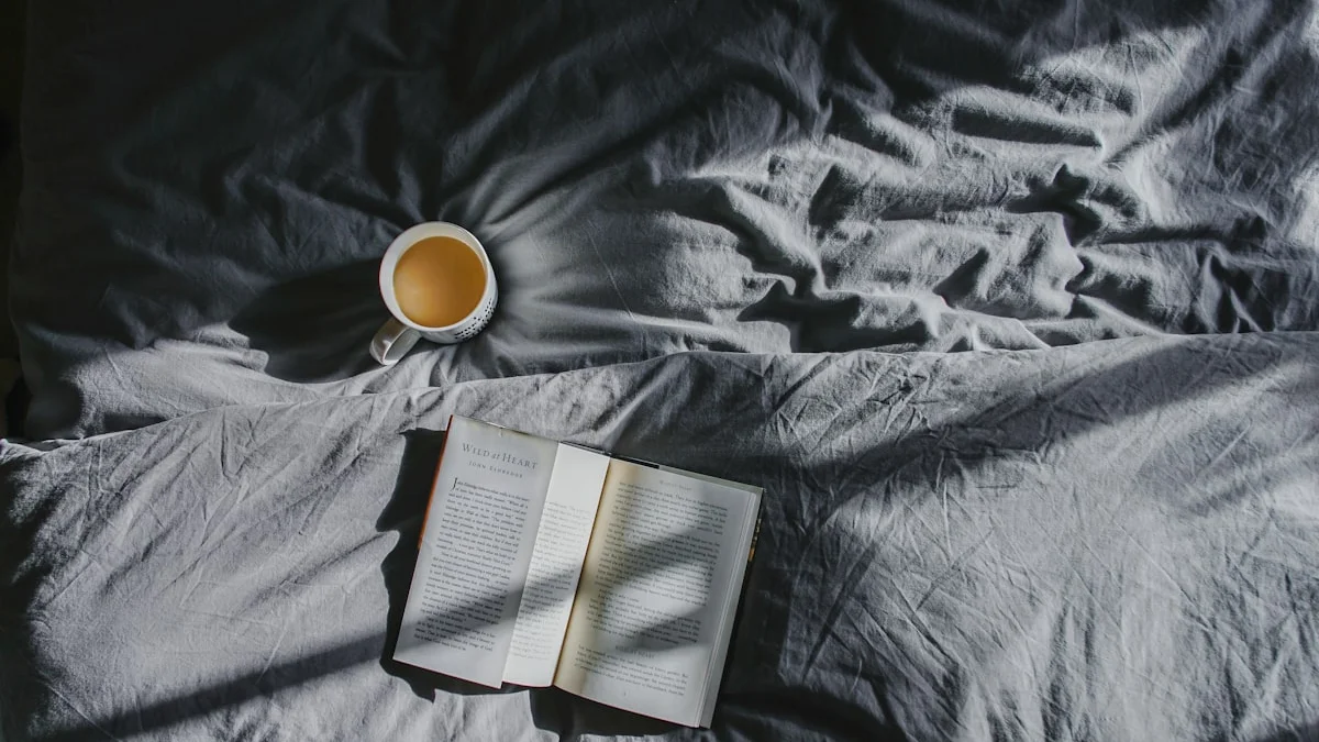 An open book and a single cup of tea on soft grey bedding - a Quiet Core Reset guide to Single-Tasking.