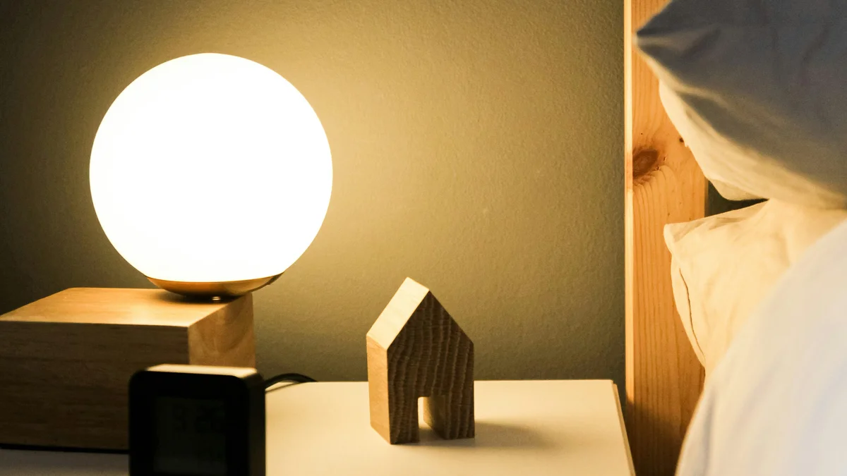 A dim, calm bedroom at dusk with soft lamplight and turned-down covers - a Quiet Core Reset guide to Sleep Recovery.