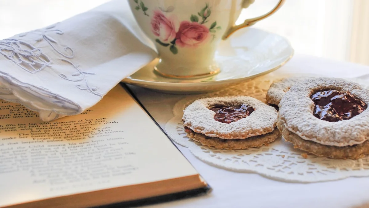 An open book beside a cup of tea and jam pastries on a lace cloth - a Quiet Core Reset guide to Slow Living.