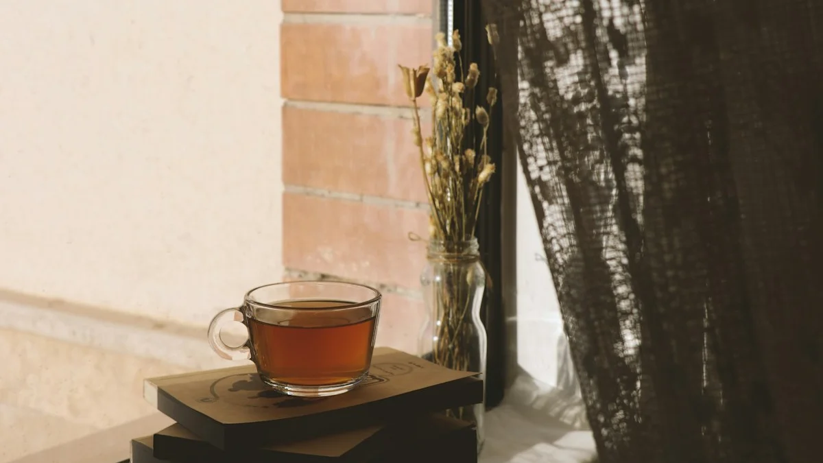 A glass cup of tea resting on a stack of books beside a sunlit window with dried flowers - a Quiet Core Reset guide to Why Slow Living Feels Impossible in a 24/7 World.