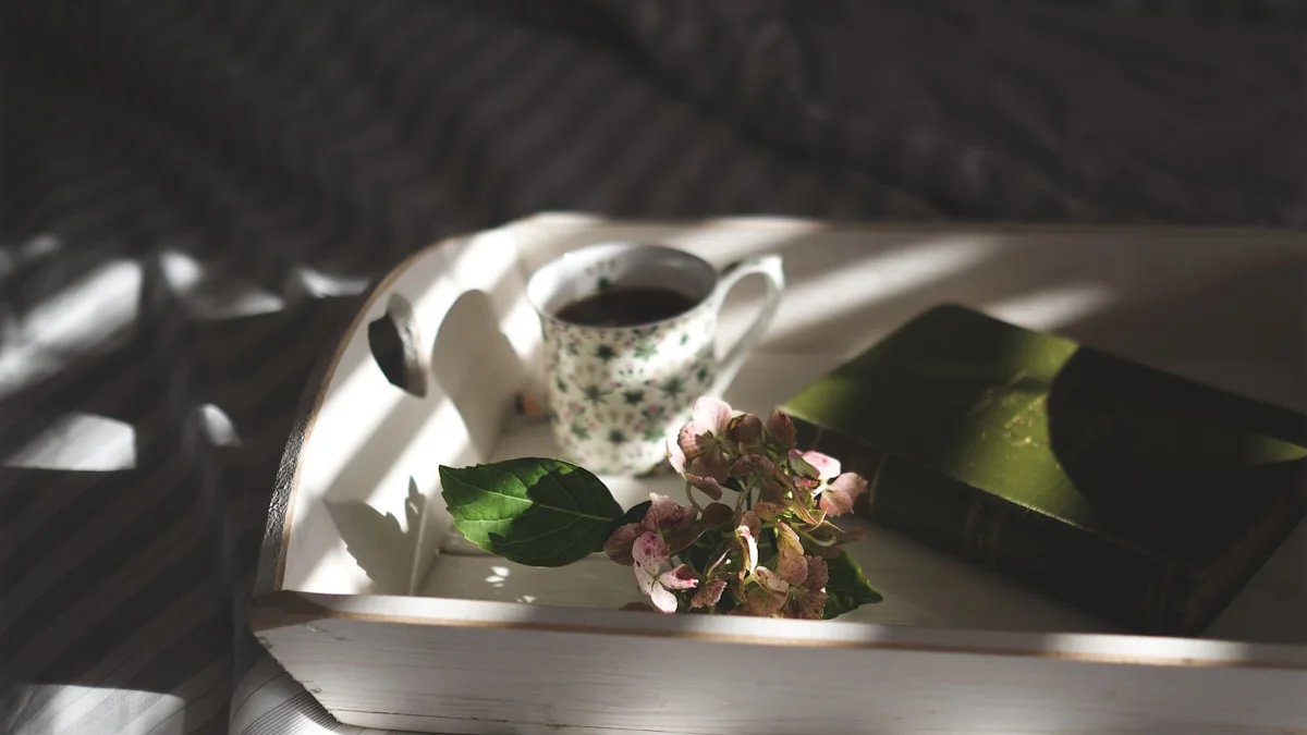 A wooden tray with a floral teacup, a worn green book and flowers in dappled window light - a Quiet Core Reset guide to Is Your Pace Serving You? A 3-Minute Slow-Living Self-Check.