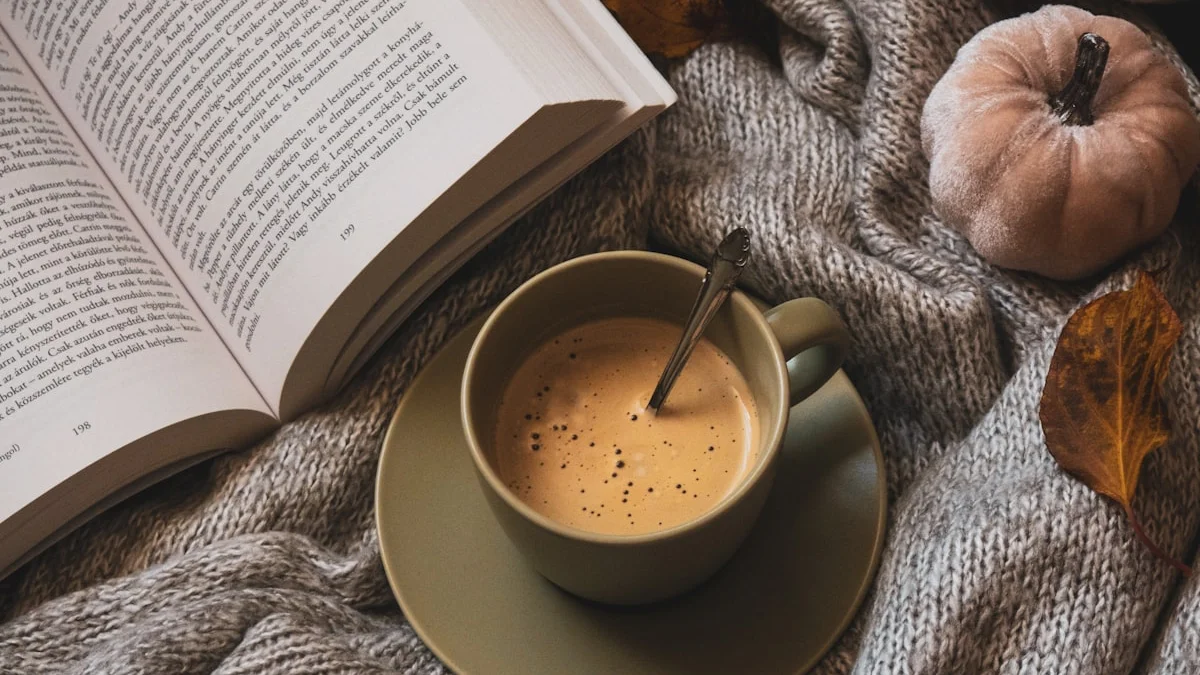 An open book and a warm latte resting on a soft knitted blanket - a Quiet Core Reset guide to Slow Living for Low-Energy Days.