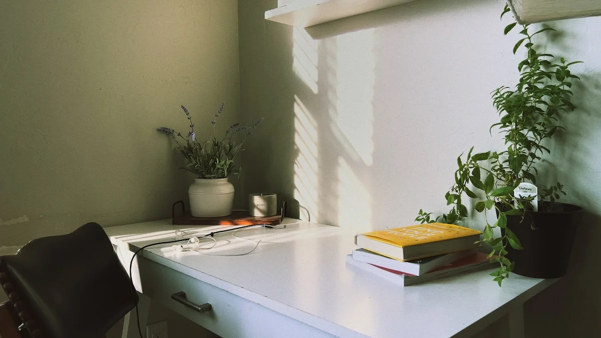 A tidy white home desk with books and plants washed in soft morning light - a Quiet Core Reset guide to Slow Living for Remote Workers.