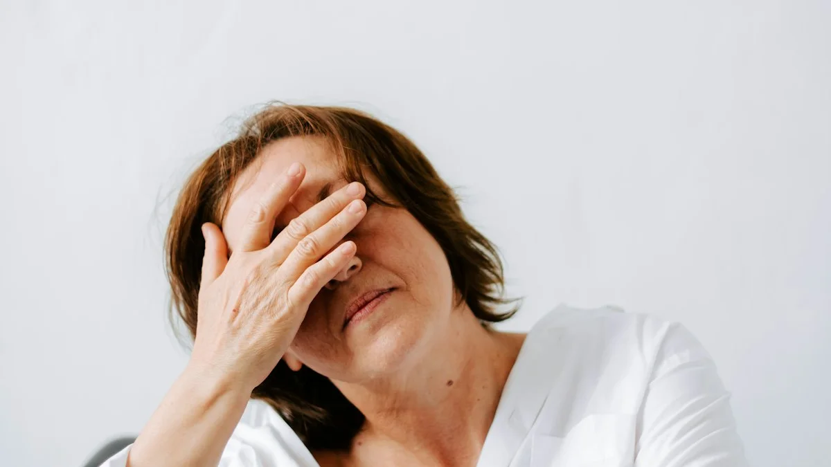 A woman in a white shirt resting one hand across her eyes in soft neutral light, quietly weary - a Quiet Core Reset guide to 9 Signs Social Comparison Is Burning You Out.